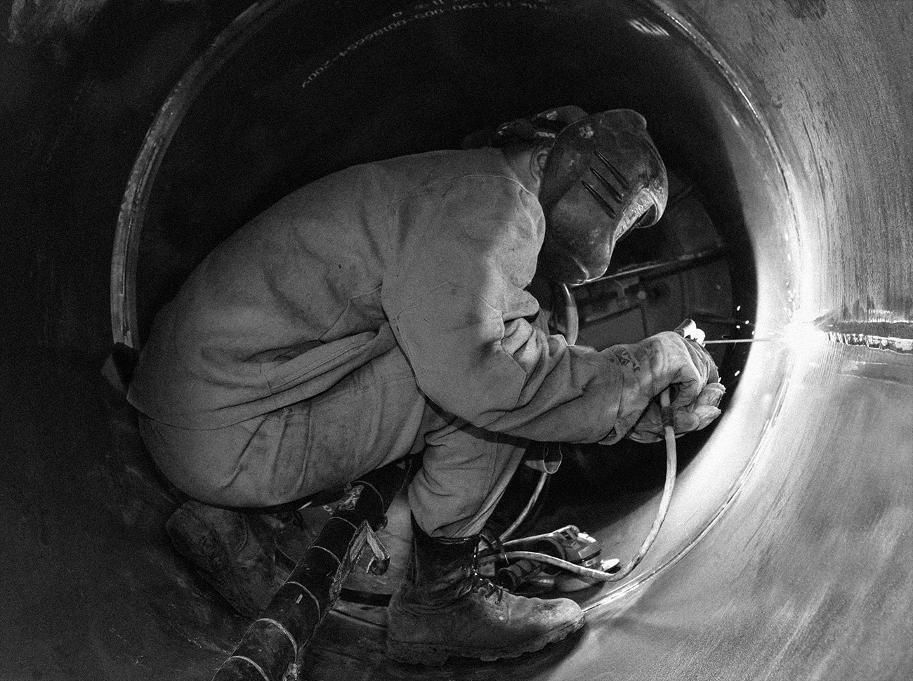 Worker welding a pipeline in Siberia Worker welding a pipeline in Siberia